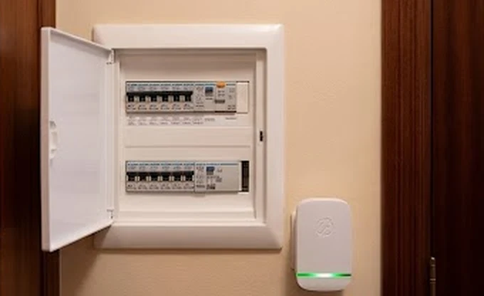 StopWatt enchufado junto al cuadro eléctrico con la luz verde encendida